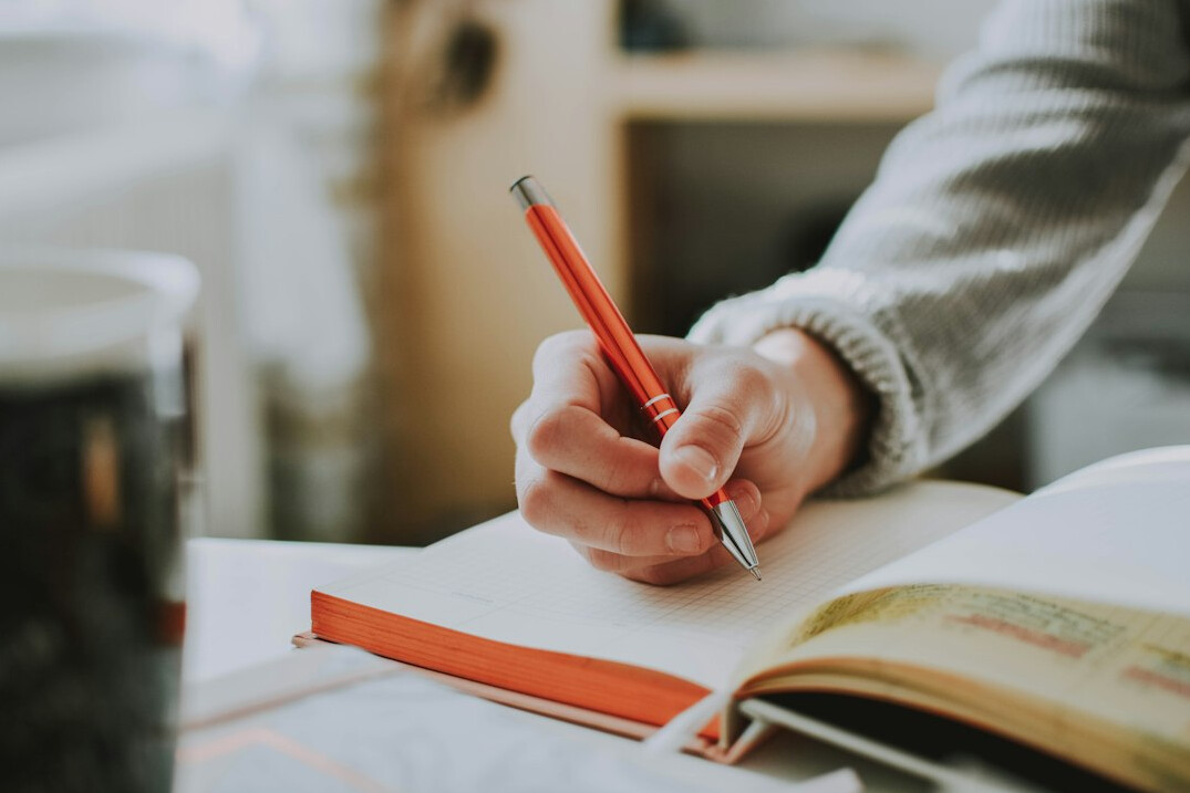person writing notes on paper